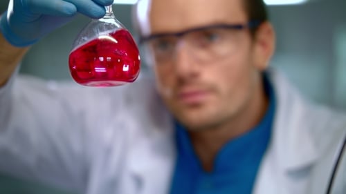 Scientist Holding Flask with Red Liquid in Laboratory