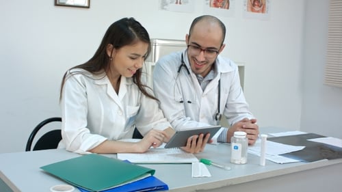 Doctors Discussing Information on Tablet in Office