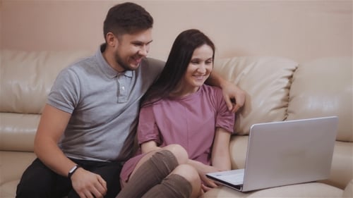 Young Couple Using Laptop Together on Couch