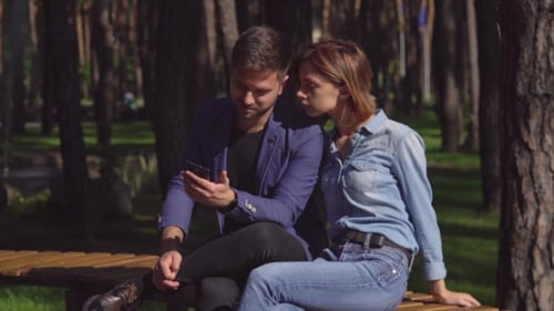 Pareja sentada en el banco Use Gadget.
