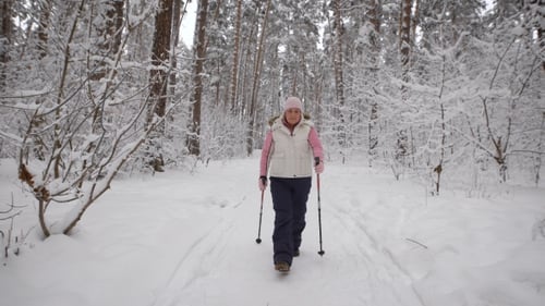 Woman Doing Nordic Walking in Snowy Winter Forest