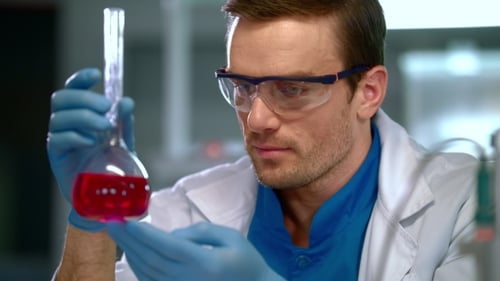 Scientist Holding Flask of Red Liquid in Lab