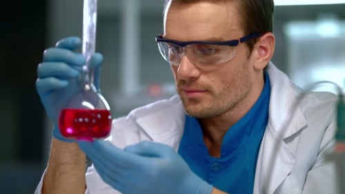 Scientist Holding Flask with Pink Liquid in Lab