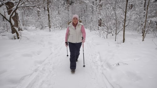 The Elderly Woman Spends the Leisure-time in the Wood. Winter Forest. The Supports the Level of Th