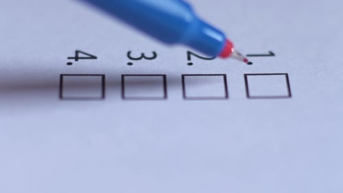 Ausgeschnitten von Geschäftsfrauen, die auf Checkliste schreiben
