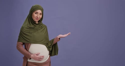 Pregnant Woman With Headscarf Holding Out Hand