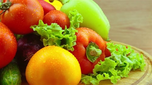Fresh Vegetables and Greens Rotating on Wooden Plate
