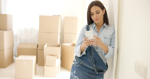 Attractive Woman Using Phone After Moving to New House