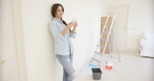 Woman Using Smartphone During Home Renovation Project