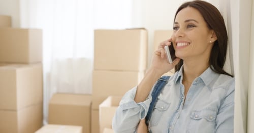 Woman Smiling Talking on Phone Moving Boxes