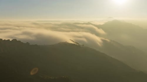 Ethereal Clouds Drifting Through a Green Mountain Range