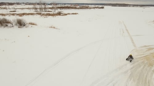ATV Riding Across Vast Snowy Landscape