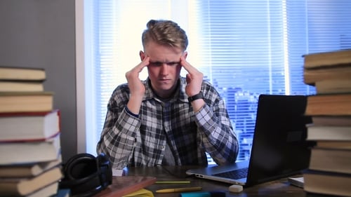 Tired and Stressed Young Student in Library