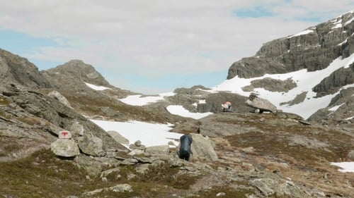 Hiker Ascends Rocky Slope in Mountain Wilderness