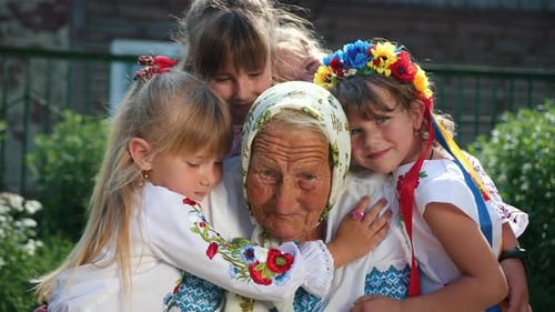 An Old Grandmother is Sitting on the Street and Reading a Book