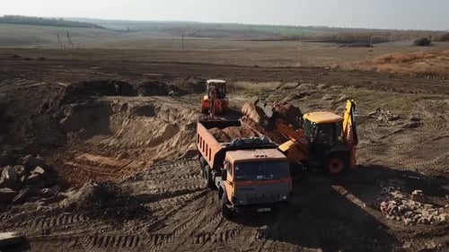 Excavator Loading Dump Truck With Dirt Aerial