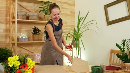 Woman Cutting Brown Craft Paper at Table