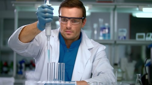 Scientist transfers liquid into test tubes