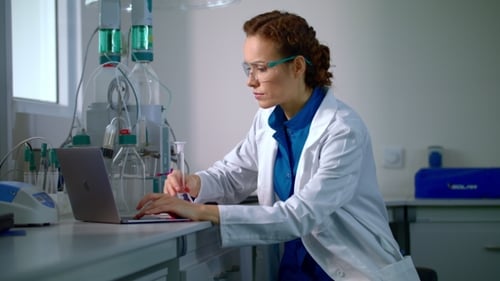 Female Scientist Typing on Laptop in Laboratory