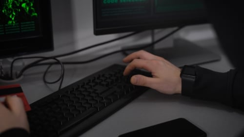 Hacker profissional insere o número de cartões de crédito de plástico em um spyware especial para obter acesso a