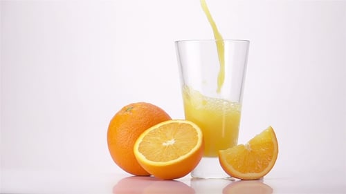 Pouring Fresh Orange Juice Into Glass Still Life