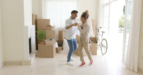 Couple Dancing in New Home, surrounded by Moving Boxes