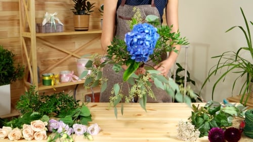 Woman Arranging Colorful Flowers Into Bouquet