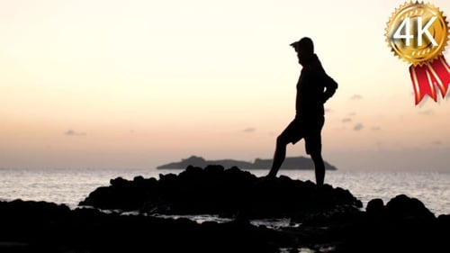 Mann Silhouette steht auf einem Felsen im Meer