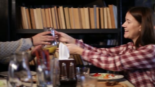 Attractive Girl Passing Carafe with Juice in Cafe