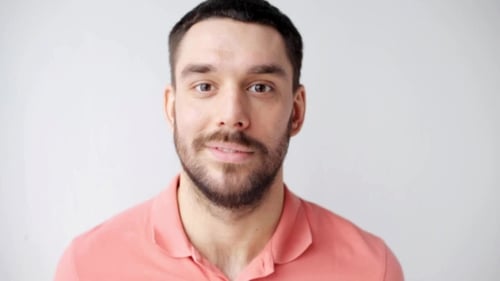 Man Smiling Close Up Against White Background