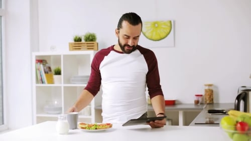 Man with Tablet Pc Eating Breakfast at Home 21