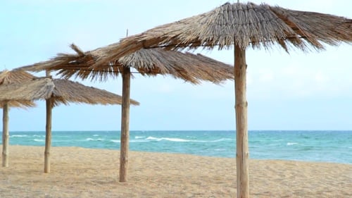 Sandy Beach With Thatched Umbrellas On A Windy Day
