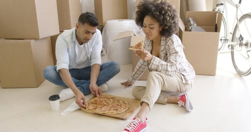 Young Couple Enjoying Pizza After Moving In