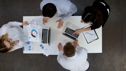 Ofice Workers Discussing Business Diagrams and Wokring on Laptops