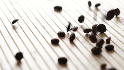 Viele geröstete Kaffeebohnen fallen herunter. Langsam