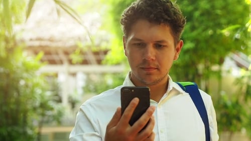 Mann benutzt Smartphone im Sommer im Freien