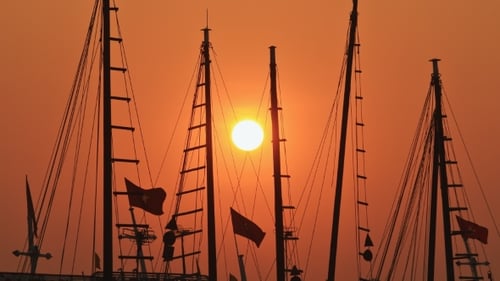 Mástiles de barcos y barcos al atardecer