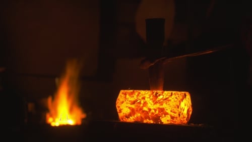 Blacksmith schmiedet Eisen in der Schmiede