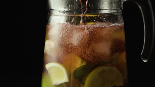 Refreshing Iced Tea Poured into Glass Pitcher