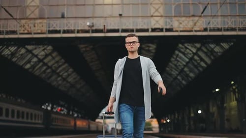 A Man is Walking Along with the Station Platform