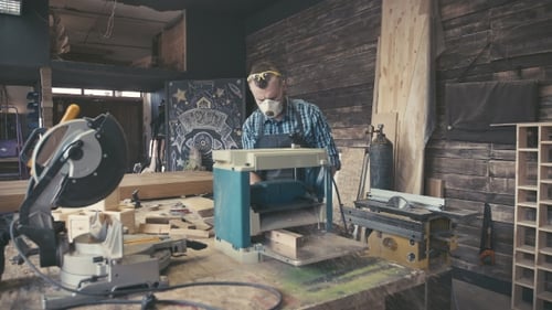 Man operating wood planer in carpentry workshop