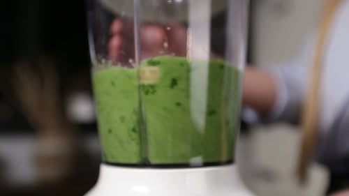 Woman Blending Ingredients To Make Green Smoothie