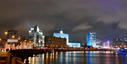 Cityscape at Night Along Riverbank