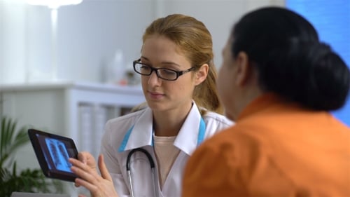 Woman Doctor Discussing X-Ray with Patient