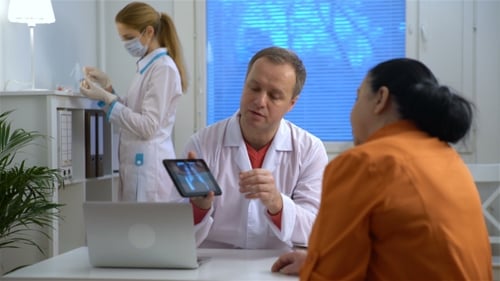 Doctor Explains X-Ray to Patient in Office