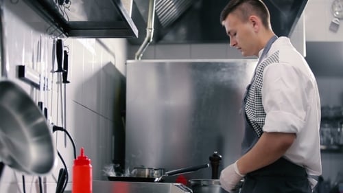 Chef Cooking Food at Stove in Kitchen