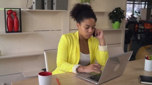 Dame multiculturelle assise sur le lieu de travail