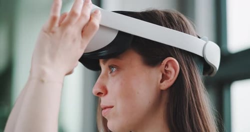 Side view of young woman putting on virtual reality headset