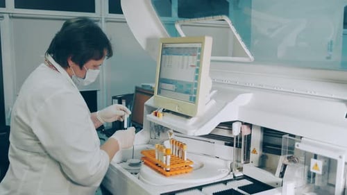 Medical Technician Analyzing Blood Sample in Modern Lab