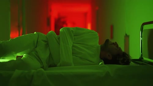 A Mad Male Patient in Straitjacket is Lying on Gurney and Going Crazy in a Mental Hospital